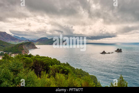 Panoramablick auf die Küste und die Berglandschaft in der Nähe von Petrovac Stadt und den felsigen Inseln Katic und Sveta Nedelja in der Adria Montenegro Stockfoto
