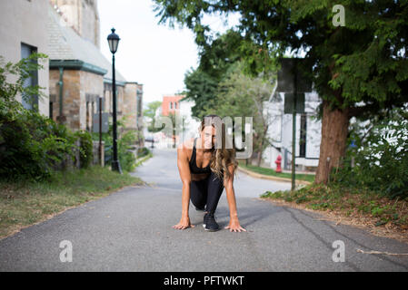 Junge Erwachsene Frau in Fitness Kleidung Ausübung im Straßenverkehr Stockfoto