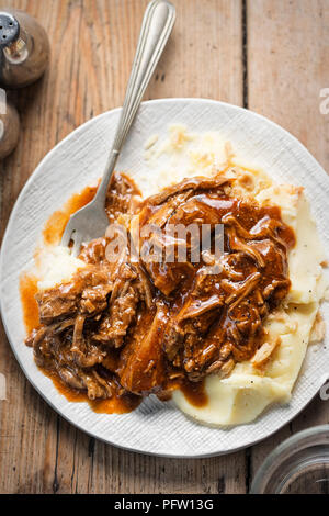 Zog Rindfleisch in Barbecue Sauce mit Kartoffelpüree & knusprig gebratenen Zwiebeln Stockfoto