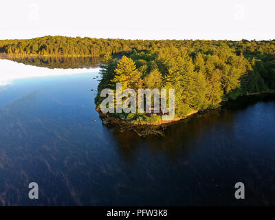 Antenne drone Bild eines Log cabin Lean - zu Schutz und Lagerfeuer auf einem See in den Adirondack Mountains. Aus der Vogelperspektive einen am Meer gelegenen Campingplatz Stockfoto