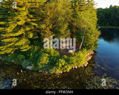 Antenne drone Bild eines Log cabin Lean - zu Schutz und Lagerfeuer auf einem See in den Adirondack Mountains. Aus der Vogelperspektive einen am Meer gelegenen Campingplatz Stockfoto