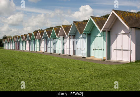 Reihe von bunten Badekabinen auf grün hinter Meer in Southsea in Portsmouth, Hampshire, England Stockfoto