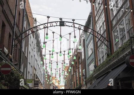 Carnaby unterzeichnen und dekorativen Lampen zwischen alten Gebäuden, Carnaby Street, London, England, 28. Oktober 2017. () Stockfoto