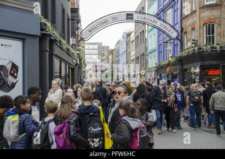 Überfüllte Carnaby Street und dem Zeichen Buchstaben "Willkommen im Carnaby Street, London, England, 28. Oktober 2017. () Stockfoto