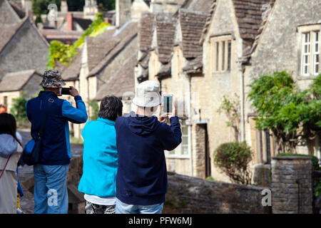 Castle Combe, Großbritannien - 9 August 2018: Touristen, die Bilder von Castle Combe, das ist ein typisch englischen Dorf oft als "schönste benannt Stockfoto