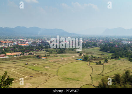 Schöne Aussicht auf die Stadt und die Felder von oben in Vang Vieng, Vientiane, Laos, Provinz an einem sonnigen Tag. Stockfoto