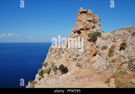 Ein Felsvorsprung auf der Spitze einer Klippe weg von Livadia nach Gera auf der griechischen Insel Tilos. Stockfoto