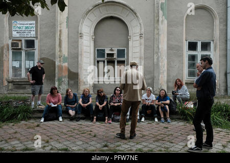 Die Teilnehmer der Reiseagentur ROOTKA, die sich auf jüdische Kulturreisen in Osteuropa spezialisiert hat, sitzen vor einer alten Synagoge aus dem Jahr 1909, Gegründet auf der Grundlage eines ehemaligen chassidischen klojz (1870) in der Stadt Tschortkiw, die einst die Heimat einer großen jüdischen Gemeinde war und von den Deutschen während des Zweiten Weltkriegs im Gebiet Ternopil (Provinz) in der Westukraine brutal vernichtet wurde. Stockfoto