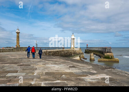 Familie einen Spaziergang entlang der Osten Pier in Whitby an der Küste von North Yorkshire, England. Stockfoto