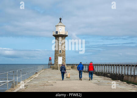 Familie einen Spaziergang entlang der Osten Pier in Whitby an der Küste von North Yorkshire, England. Stockfoto