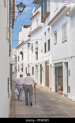 Alte Männer mit einem Stock in einer ruhigen Straße mit weiß getünchten Häusern in Mijas, Andalusien Spanien an einem sonnigen Tag Stockfoto