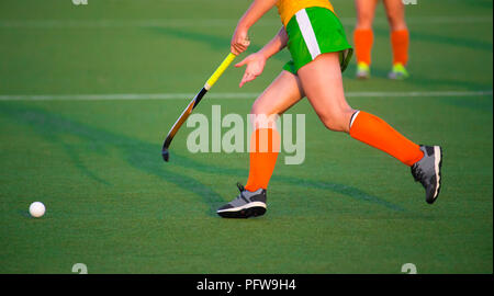 Jungen Hockeyspieler Frau mit Ball im Angriff spielen Hockey Game Stockfoto