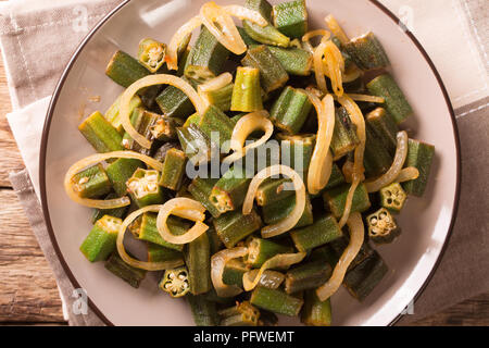 Vegetarische gesunde Ernährung: Grün okra gebraten mit Zwiebeln close-up auf einem Teller auf den Tisch. horizontal oben Ansicht von oben Stockfoto