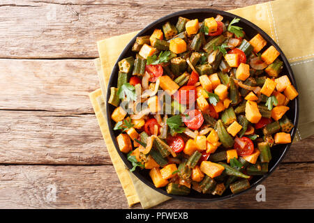 Traditionelles Rezept Ragout von okra, süße Kartoffeln, Tomaten, Zwiebeln und Kräutern close-up auf einem Teller auf dem Tisch. horizontal oben Ansicht von oben Stockfoto