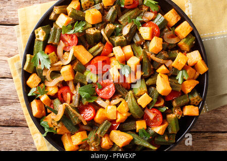 Gemüseeintopf okra, süße Kartoffeln, Tomaten, Zwiebeln und Kräutern closeup auf einem Teller auf den Tisch. horizontal oben Ansicht von oben Stockfoto