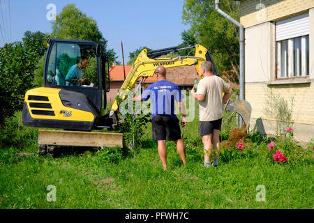 Mann mit einem mechanischen Digger in einem Garten ein Graben, Zala Ungarn dig Stockfoto