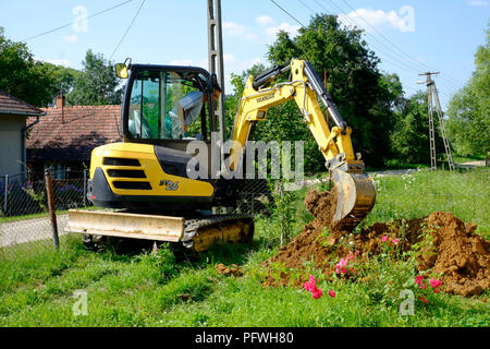 Mann mit einem mechanischen Digger in einem Garten ein Graben, Zala Ungarn dig Stockfoto