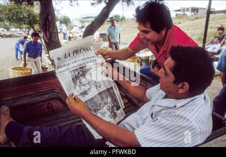 Managua, Nicaragua, Wahlen, Feb 1990; zwei Freunde lesen La Prensa Tageszeitung zeigen Unterstützung für Violetta Chamorro die UNO Partei. Stockfoto