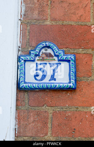 Haus Nummer 57 Zeichen - Keramische Fliese auf Red brick wall Stockfoto
