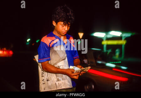 Managua, Nicaragua, Wahlen, Feb 1990; ein Teenager den Verkauf der Tageszeitung La Prensa, Fahrer, die an einer belebten Kreuzung in der Nacht. Stockfoto