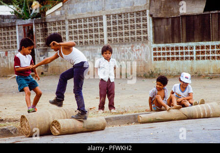 Managua, Nicaragua, Wahlen, Feb 1990; spielende Kinder auf dem Schnitt bis Stamm einer Palme. Stockfoto