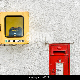 DEFIBRILLATOR UND RED LETTER BOX auf einer weißen Wand Stockfoto