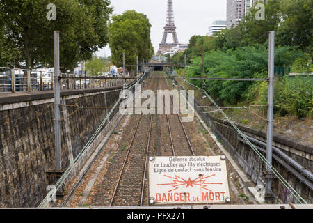 Paris railroad - ein Zeichen in französischer Sprache Warnung vor Stromschlägen, mit dem Eiffelturm im Hintergrund, Frankreich, Europa. Stockfoto