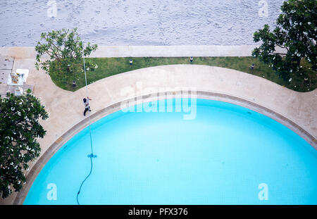 Mann Reinigung Schwimmbad mit Staubsauger Stockfoto