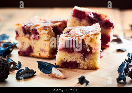 Frisch gebackener Kuchen mit Kirschen auf Holztisch mit Zucker auf der Oberseite Stockfoto