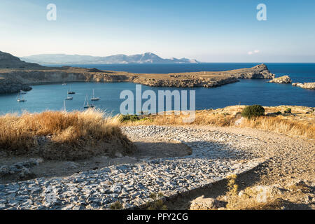 Thi ist der alte Stein Straße, die Kurven es weg bis zu der Akropolis in Lindos auf der griechischen Insel Rhodos. Stockfoto