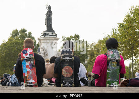 Paris Skater - Drei Pariser Jungen von hinten lehnte sich auf ihren Skateboards auf dem Place de la Republique. Frankreich, Europa. Stockfoto