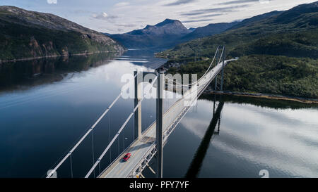 Luftaufnahme der Brücke Rombaksbrua über Straumen Bucht von Ofotfjord. Autos auf der Brücke und die Berge im Hintergrund. Narvik, Norwegen Stockfoto