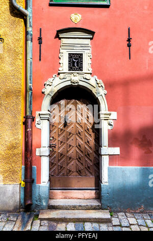 Eine reich verzierte Holztür eines roten Haus in Gamla Stan (Altstadt), Stockholm, Schweden Stockfoto