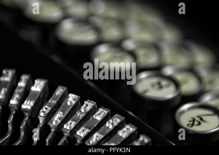 Vintage Keyboarding: Classic 1923 Schreibmaschine mit bokeh Tastatur und schwarzen Hintergrund. Geeignet für Hotels/Motels, die zu einem Business Klientel gerecht zu werden. Stockfoto