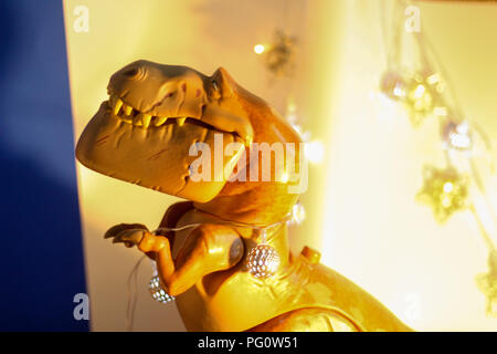 Spielzeug Szene - Butch der Dinosaurier Spielzeug gegen eine festliche Sternenhimmel blau und weißen Hintergrund. Stockfoto