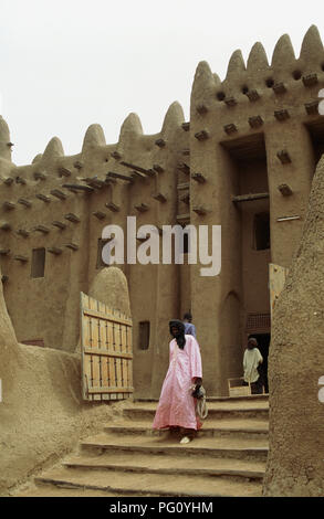 Mann mit rosa Robe zu Fuß die Schritte von der Großen Moschee von Djenne, Mali für redaktionelle NUR VERWENDEN Stockfoto