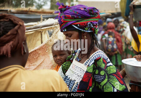Frau in Buntes Kleid mit Baby am Montag Markt in der Großen Moschee von Djenne, Mali für redaktionelle NUR VERWENDEN Stockfoto