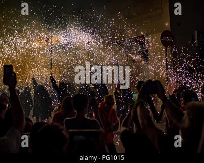 Barcelona, Spanien. August 22, 2018 - Menschen im Feuer führen Sie "CORREFOC" Ritual in Gracia Festival in Barcelona feiern Stockfoto