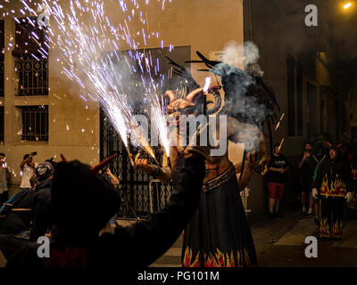 Barcelona, Spanien. August 22, 2018 - Menschen im Feuer führen Sie "CORREFOC" Ritual in Gracia Festival in Barcelona feiern Stockfoto