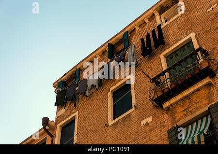 Hängende Kleidung in einer kleinen Gasse im mittelalterlichen Zentrum von Venedig Stockfoto