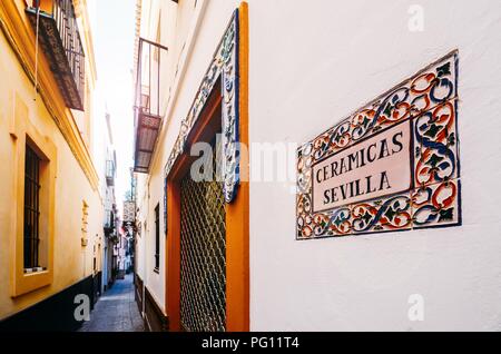 Weitwinkel Blick auf eine schmale Straße mit Keramik Shop im historischen Zentrum von Sevilla, Andalusien, Spanien Stockfoto