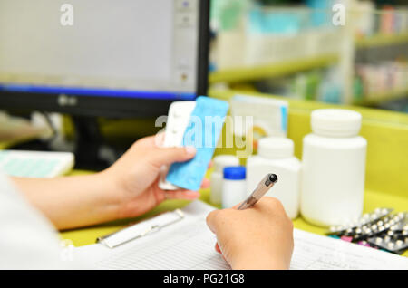 Nahaufnahme der Ärztin hand Pillen Packung und schreiben Rezept. Gesundheit, Medizin und Pharmazie. Stockfoto