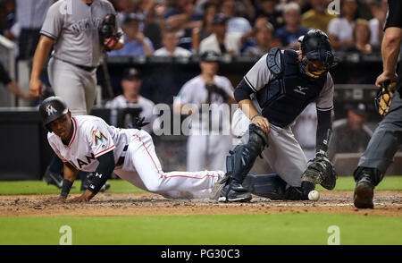 Miami, Florida. 22. August 2018: Miami Marlins Mittelfeldspieler Magneuris Sierra (34) Kerben an der Unterseite des sechsten Inning, Vergangenheit New York Yankees catcher Austin Romine (28), während ein MLB-Spiel zwischen den New York Yankees und die Miami Marlins am die Marlins Park in Miami, Florida. Die Marlins gewann 9-3. Mario Houben/CSM Credit: Cal Sport Media/Alamy leben Nachrichten Stockfoto