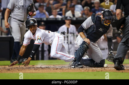 Miami, Florida. 22. August 2018: Miami Marlins Mittelfeldspieler Magneuris Sierra (34) Kerben an der Unterseite des sechsten Inning, Vergangenheit New York Yankees catcher Austin Romine (28), während ein MLB-Spiel zwischen den New York Yankees und die Miami Marlins am die Marlins Park in Miami, Florida. Die Marlins gewann 9-3. Mario Houben/CSM Credit: Cal Sport Media/Alamy leben Nachrichten Stockfoto