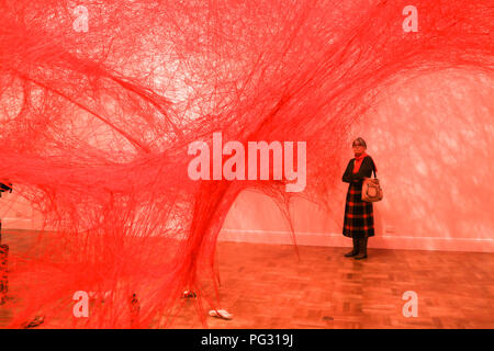 Adelaide, Australien. 23 Aug, 2018. Eine groß angelegte Installation durch die japanische Künstlerin Chiharu Shiota "Abwesenheit verkörperte "Schaffung einer riesigen tangled weblike Struktur von mehr als 180 km von kunstvoll gewebte Bedrohungen aus roten Wolle aufgereiht, von den Wänden und der Decke wurde öffnet sich an der kunst-Galerie von Australien in Adelaide Credit: Amer ghazzal/Alamy leben Nachrichten Stockfoto