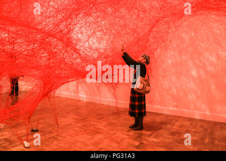 Adelaide, Australien. 23 Aug, 2018. Eine groß angelegte Installation durch die japanische Künstlerin Chiharu Shiota "Abwesenheit verkörperte "Schaffung einer riesigen tangled weblike Struktur von mehr als 180 km von kunstvoll gewebte Bedrohungen aus roten Wolle aufgereiht, von den Wänden und der Decke wurde öffnet sich an der kunst-Galerie von Australien in Adelaide Credit: Amer ghazzal/Alamy leben Nachrichten Stockfoto