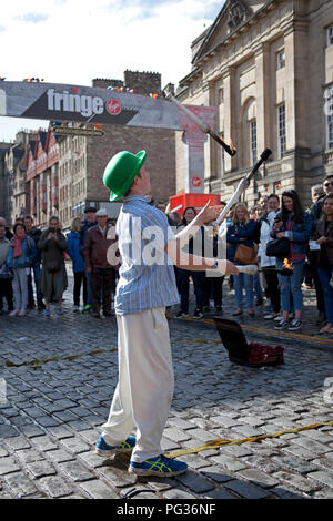 Edinburgh, Schottland, Großbritannien, 23. August 2018. Edinburgh Fringe Festival, Royal Mile, der 12 Jahre alte Patrick aus Edinburgh spielt mit dem Feuer mit seinem Balanceakt erscheinen an seinem ersten Fringe als Straßenmusikant Stockfoto