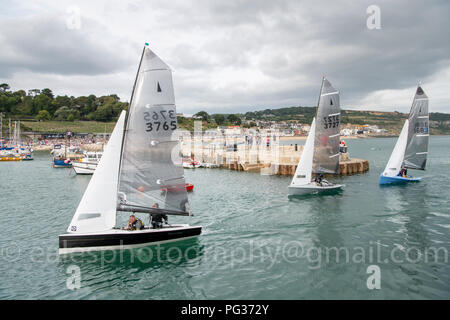 Lyme Regis, Dorset UK 23. August 2018. Merlin Klasse dingies Segel rechts in einem überfüllten Hafen in böigen Winde nach einem Tage racing Konkurrenz an den Nationalen Meisterschaften Segeln. Credit: Julian Eales/Alamy leben Nachrichten Stockfoto