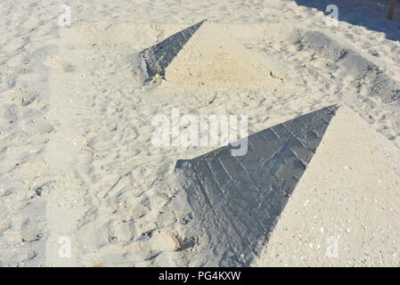 Am Strand am Schwarzen Meer wurden tagsüber zwei Pyramiden aus weißem Sand und Muscheln gebaut Stockfoto