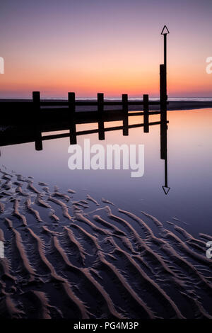 Holz- buhnen in Gezeiten Pool auf Rhyl Strand an der Küste von Nordwales Stockfoto